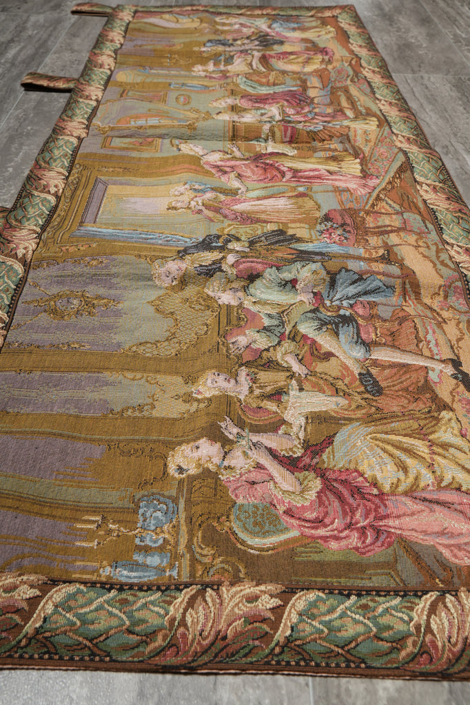 Decorative tapestry with intricate designs and figures on a wooden floor.