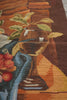 Load image into Gallery viewer, Close-up of a needlepoint or tapestry depicting a still life scene with fruit and a vase.