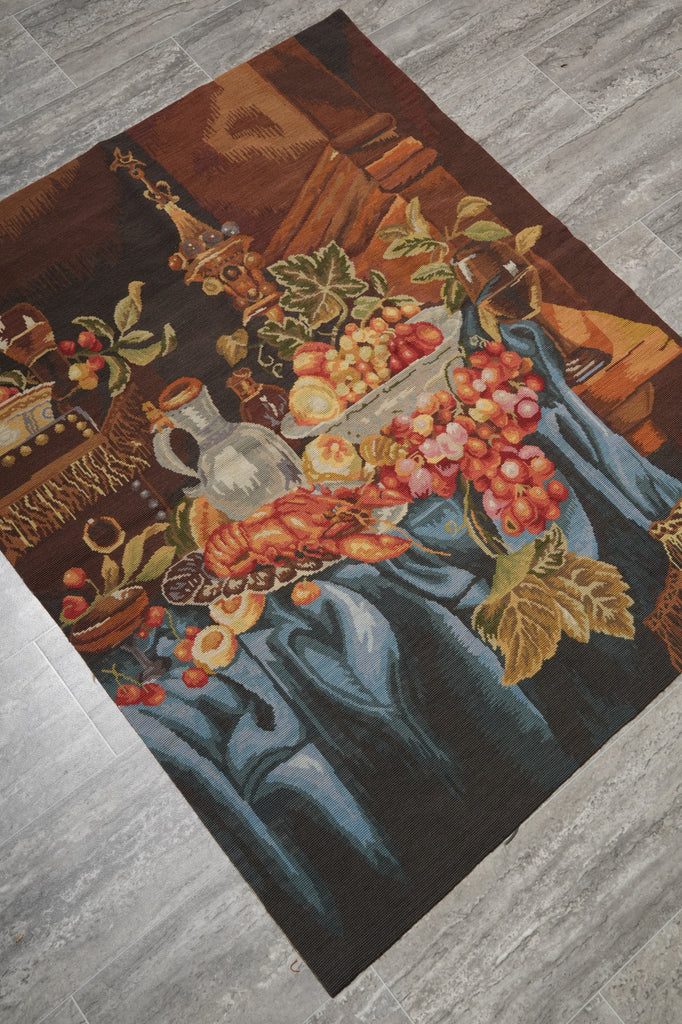 Decorative rug with floral and fruit design on a wooden floor