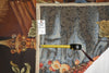 Load image into Gallery viewer, Tape measure on a tapestry with intricate designs and patterns.