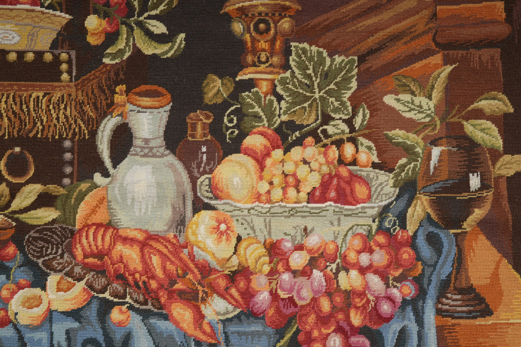 Decorative tapestry with fruits, vegetables, and a pitcher on a wooden table.