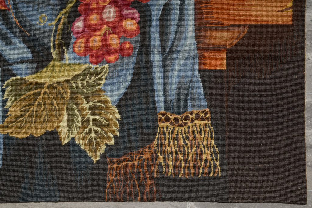 Close-up of a detailed tapestry with a person holding grapes and leaves.