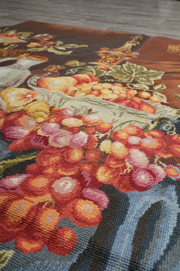 Close-up of a floral tapestry with vibrant colors on a wooden surface.