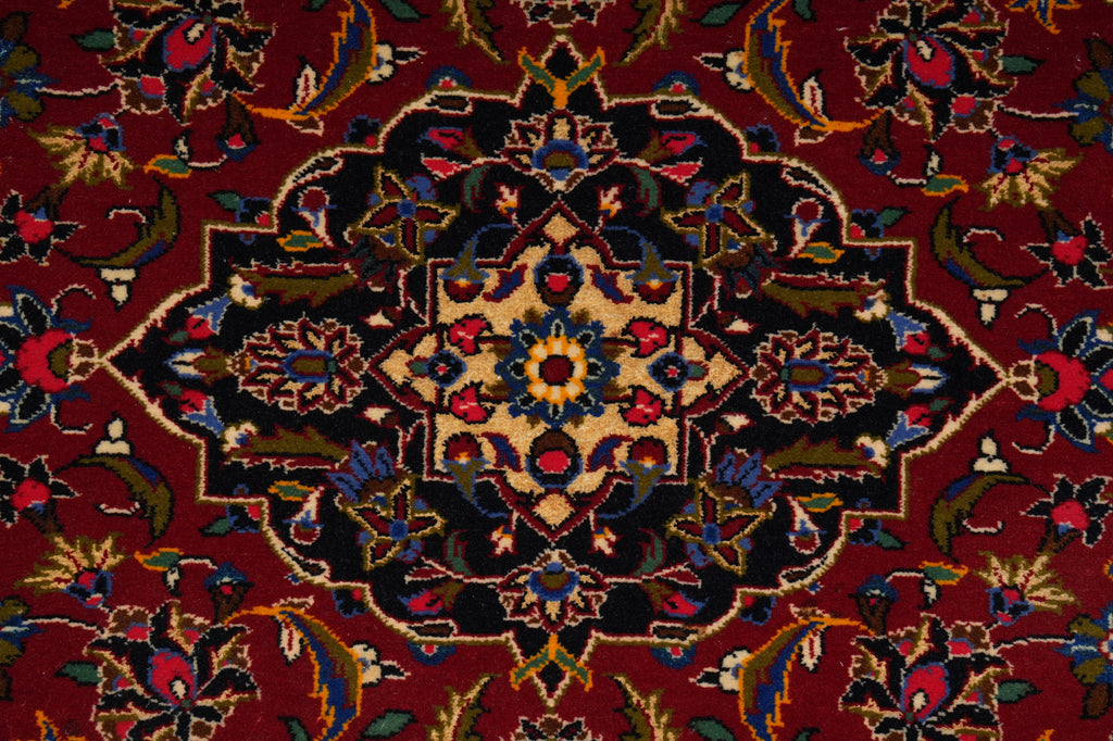 Close-up of a patterned rug with intricate designs on a red background