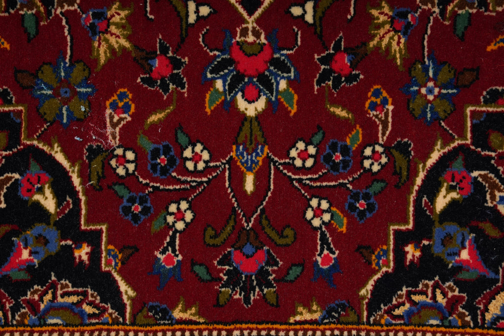 Close-up of a patterned rug with intricate designs on a red background