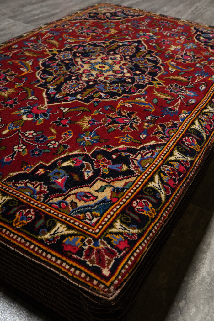 Close-up of a patterned rug with intricate designs on a gray surface