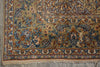 Load image into Gallery viewer, A close-up of an ornate patterned area rug showing its detailed floral design, borders, and fringed edge on a gray floor.