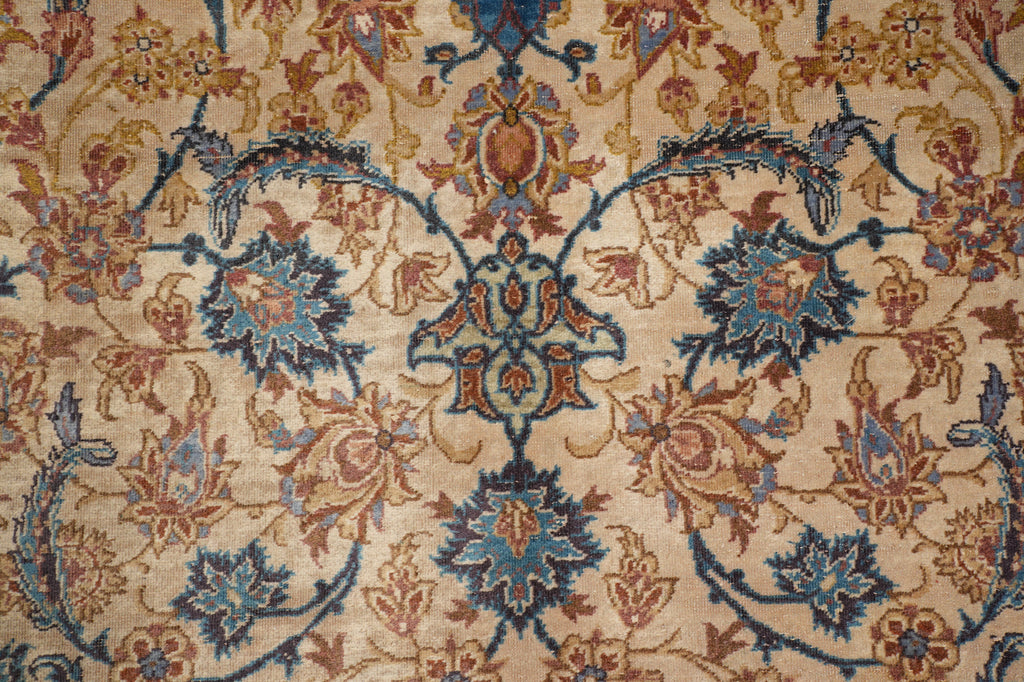 Close-up of an ornate floral patterned rug with a beige background and blue, rust, and brown motifs.
