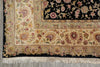 Load image into Gallery viewer, A close-up of an ornate area rug corner showing a cream floral field, detailed borders in beige and burgundy, a black central field with floral motifs, and cream fringe at the bottom.