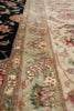 Load image into Gallery viewer, Close-up of an ornate patterned rug showing floral motifs and a decorative border in cream, pink, green, and black.