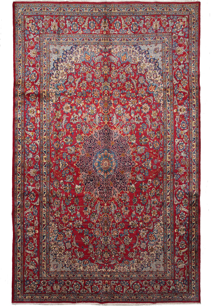 A traditional oriental area rug with a rich red field, intricate floral motifs, and a detailed multi-colored border, shown flat against a white background.