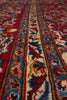 Load image into Gallery viewer, A close-up of a patterned rug showing detailed woven bands in red, blue, cream, and orange with floral motifs.