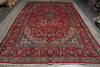 Load image into Gallery viewer, A large traditional Persian-style area rug with a deep red field, ornate floral motifs, and a detailed multi-colored border, displayed flat.