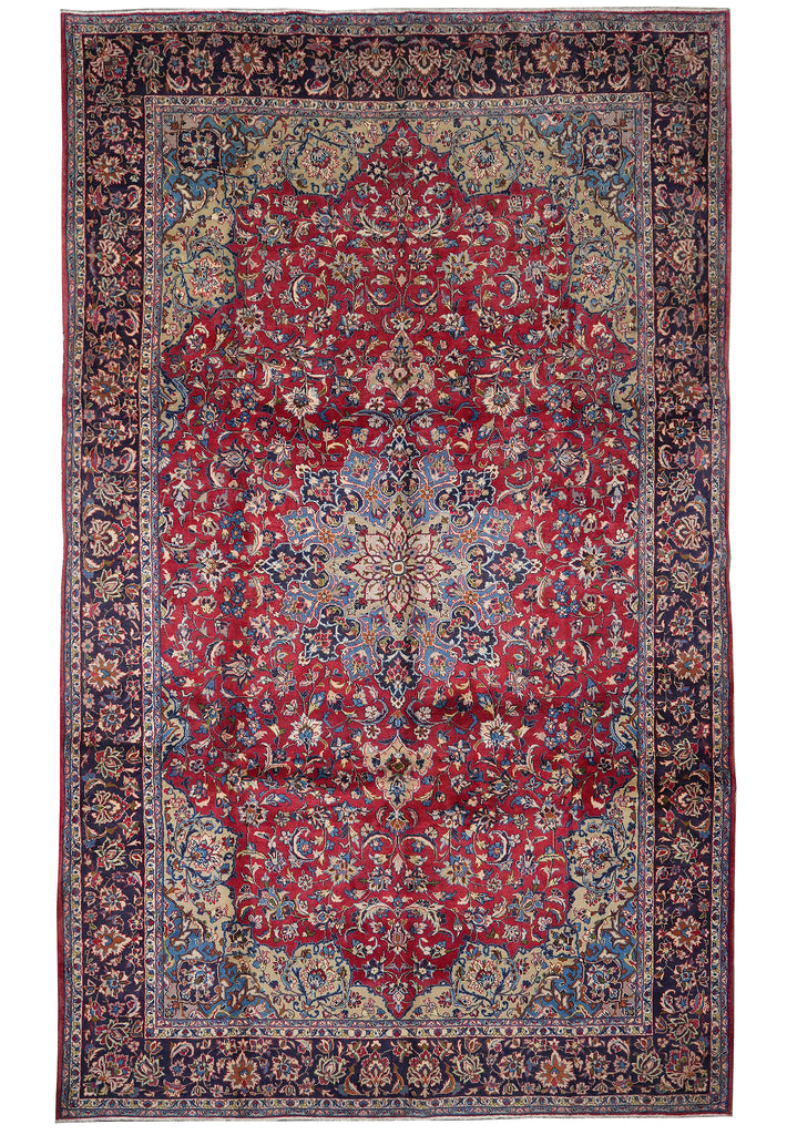 A traditional oriental area rug with a deep red central field, intricate floral motifs, and a dark navy blue border with beige and cream details.