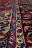 Load image into Gallery viewer, A close-up view of a traditional patterned rug with ornate floral and scroll motifs in cream, red, blue, green, and dark navy tones.