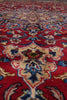 Load image into Gallery viewer, A close-up of a traditional patterned rug with a deep red field, cream central medallion, and blue floral motifs.