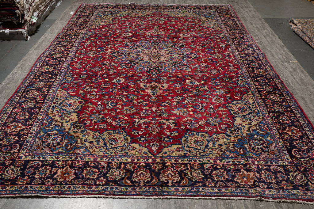 A traditional Persian-style area rug with a deep red central field, ornate floral motifs, and a dark navy blue border.