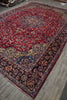 Load image into Gallery viewer, A traditional oriental area rug with a red field, dark navy borders, and intricate floral motifs in blue, gold, and beige.