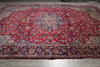 Load image into Gallery viewer, A large traditional oriental area rug with a dominant red field, featuring an intricate floral pattern and a dark navy blue border.