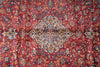 Load image into Gallery viewer, A close-up of an ornate Persian-style rug with a deep red background, featuring a large central medallion and intricate floral motifs in beige, blue, and gold.