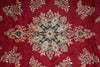 Load image into Gallery viewer, A close-up of a red patterned textile or rug featuring a large central medallion and repeating floral motifs in beige, blue, and gold tones.