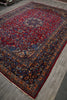 Load image into Gallery viewer, A traditional Persian-style area rug with a red field, dark navy borders, and intricate floral motifs in blue, gold, and beige.