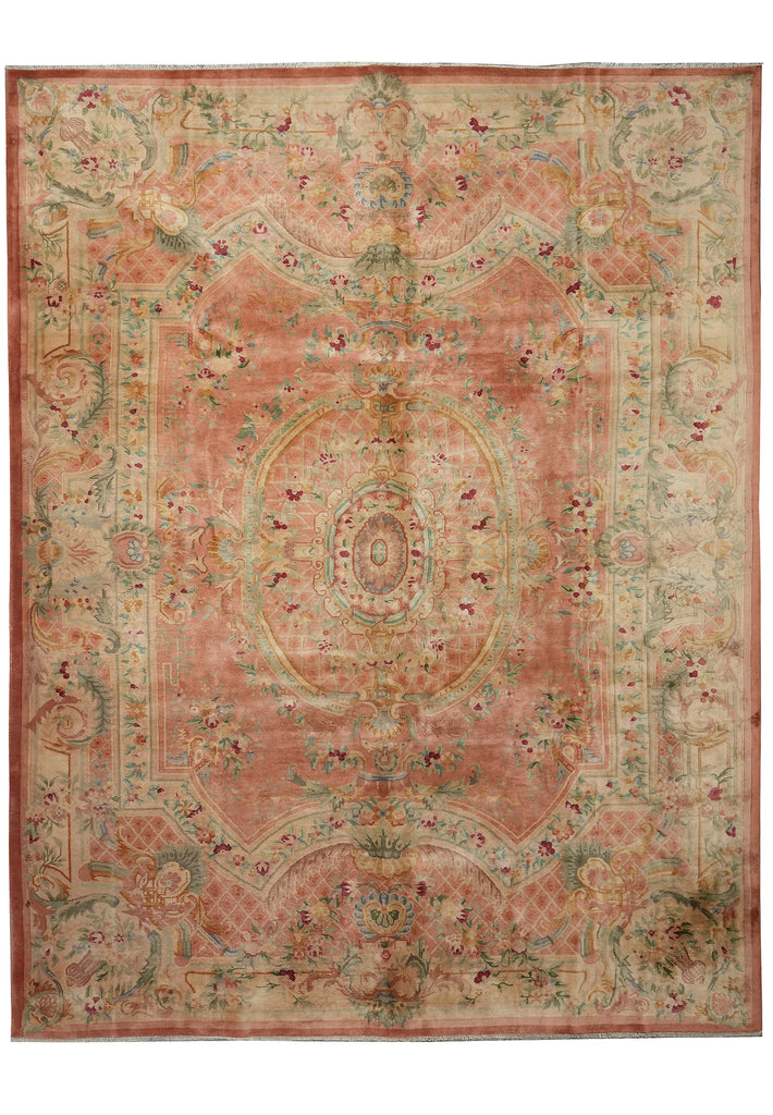 A rectangular vintage-style area rug with an ornate medallion and floral pattern in muted dusty pink, beige, sage green, and terracotta tones, shown flat against a white background.