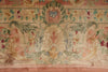 Load image into Gallery viewer, A close-up of an ornate vintage-style rug featuring a central floral medallion and scrolling motifs in muted pink, beige, green, and blue tones.