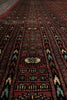 Load image into Gallery viewer, A close-up view of a traditional patterned rug with a deep red field, black borders, and cream and light blue geometric motifs.