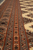 Load image into Gallery viewer, Close-up of a patterned rug showing woven geometric bands in brown, beige, muted blue-gray, and black.