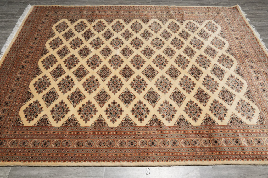A rectangular area rug with a traditional Persian-style geometric lattice pattern in beige, brown, and rust red, laid flat on a gray tiled floor.