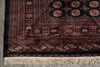 Load image into Gallery viewer, A close-up of a traditional patterned rug showing its detailed border, geometric motifs, and cream-colored fringe at the bottom.