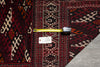 Load image into Gallery viewer, A close-up view of a traditional patterned rug with a deep red and black base, cream and beige geometric motifs.