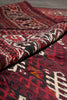 Load image into Gallery viewer, A close-up of a folded patterned textile, likely a rug or throw blanket, showing a deep red, black, and cream geometric tribal design.