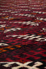 Load image into Gallery viewer, A close-up of a woven textile with a bold geometric pattern in deep red, black, cream, and orange.