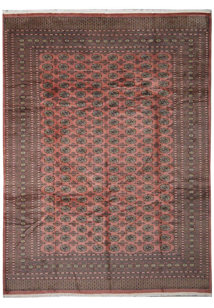 A rectangular area rug with a dusty rose pink field, decorated with repeating medallion motifs in dark green and beige, surrounded by a wide dark brown patterned border.