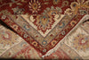 Load image into Gallery viewer, A folded traditional oriental rug with an intricate floral and geometric pattern in red, beige, blue, and brown tones, showing its woven texture and fringe detail.