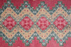Load image into Gallery viewer, A close-up of a patterned rug featuring a geometric design with red diamond medallions, beige sections, and gray stepped borders.