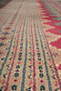 Load image into Gallery viewer, Close-up of a patterned rug with horizontal bands of geometric and tribal motifs in beige, red, blue, and black.