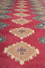 Load image into Gallery viewer, A close-up of a patterned rug featuring a deep red background with large beige diamond medallions and blue accents.
