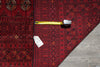 Load image into Gallery viewer, A red and black patterned rug laid flat on a gray tiled floor, with a yellow tape measure and a white price tag placed on top.