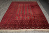 Load image into Gallery viewer, A rectangular red oriental rug with intricate geometric patterns and beige fringe, laid flat on a gray wood floor.