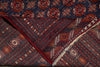Load image into Gallery viewer, A folded patterned textile, likely a rug or scarf, showing a dark navy blue base with red, orange, and cream geometric and floral motifs, finished with a fringed edge.