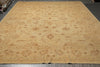 Load image into Gallery viewer, A large beige area rug with an intricate traditional floral and paisley pattern in warm tan and brown tones, laid out on a dark floor.