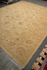 Load image into Gallery viewer, A large beige area rug with an intricate brown and tan floral and paisley pattern, photographed from an overhead angle on a dark gray floor.