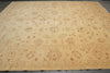 Load image into Gallery viewer, A large beige and tan area rug with an intricate traditional floral and paisley pattern, laid flat on a dark gray floor.