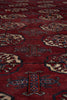 Load image into Gallery viewer, A close-up of a red patterned rug with repeating geometric and floral motifs in beige, blue, and brown.