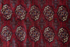 Load image into Gallery viewer, A close-up of a traditional patterned rug featuring a deep red field with repeating beige medallions and dark blue geometric accents.