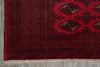 Load image into Gallery viewer, A close-up of a red and black patterned rug showing the detailed geometric borders and fringe.