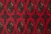 Load image into Gallery viewer, A close-up of a red patterned textile or rug featuring repeating geometric medallion motifs in black, beige, and muted brown.